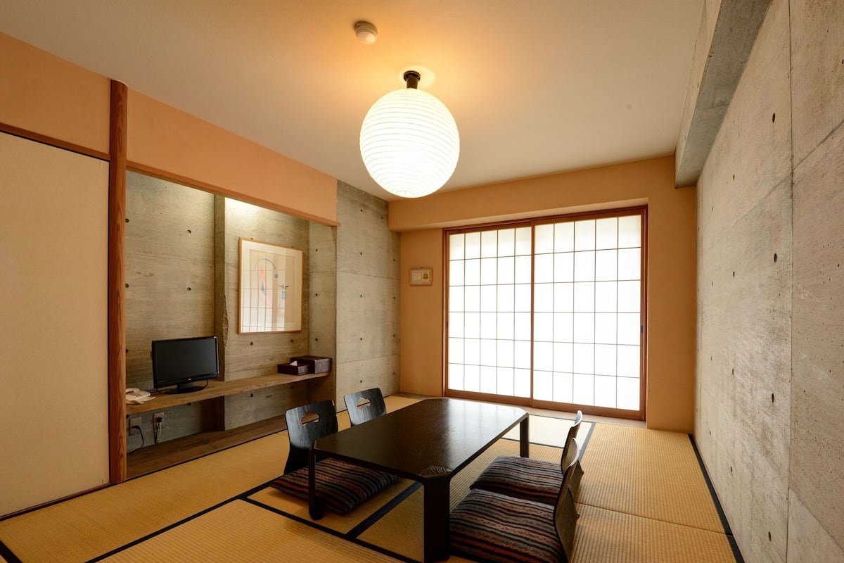 A traditional Japanese-style room with tatami flooring, a low table, and shoji screens.