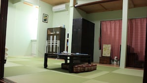 A tatami mat room with a low table, a cabinet, and a sliding door.