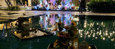 Een buitenzwembad, parasols bij het zwembad en ligstoelen