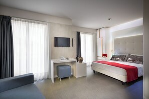 Una habitación de hotel moderna con cama, escritorio, silla y televisor.