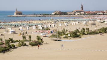 Praia particular, areia branca, espreguiçadeiras, guarda-sóis