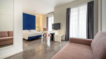 Une chambre d’hôtel équipée d’un lit, d’un bureau, d’une télévision et d’un canapé.