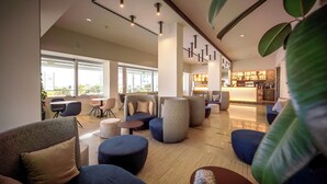 A modern lounge area with seating, a bar, and large windows. - Hotel Garden Sea (Caorle)
