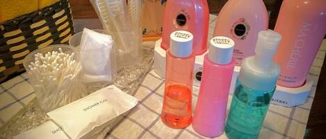 A table with various toiletries including a shower cap, cotton swabs, and bottles of lotion and shampoo.