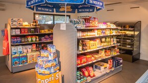 A grocery store with a variety of products on shelves and a display stand in the center. - First Camp Ekudden Mariestad (Mariestad)