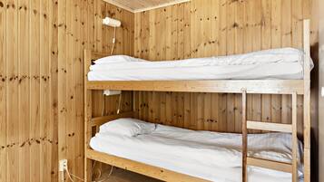 A bunk bed room with wooden walls and a white ceiling.
