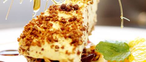A dessert with a crispy top, a leaf garnish, and a fruit slice on a plate.
