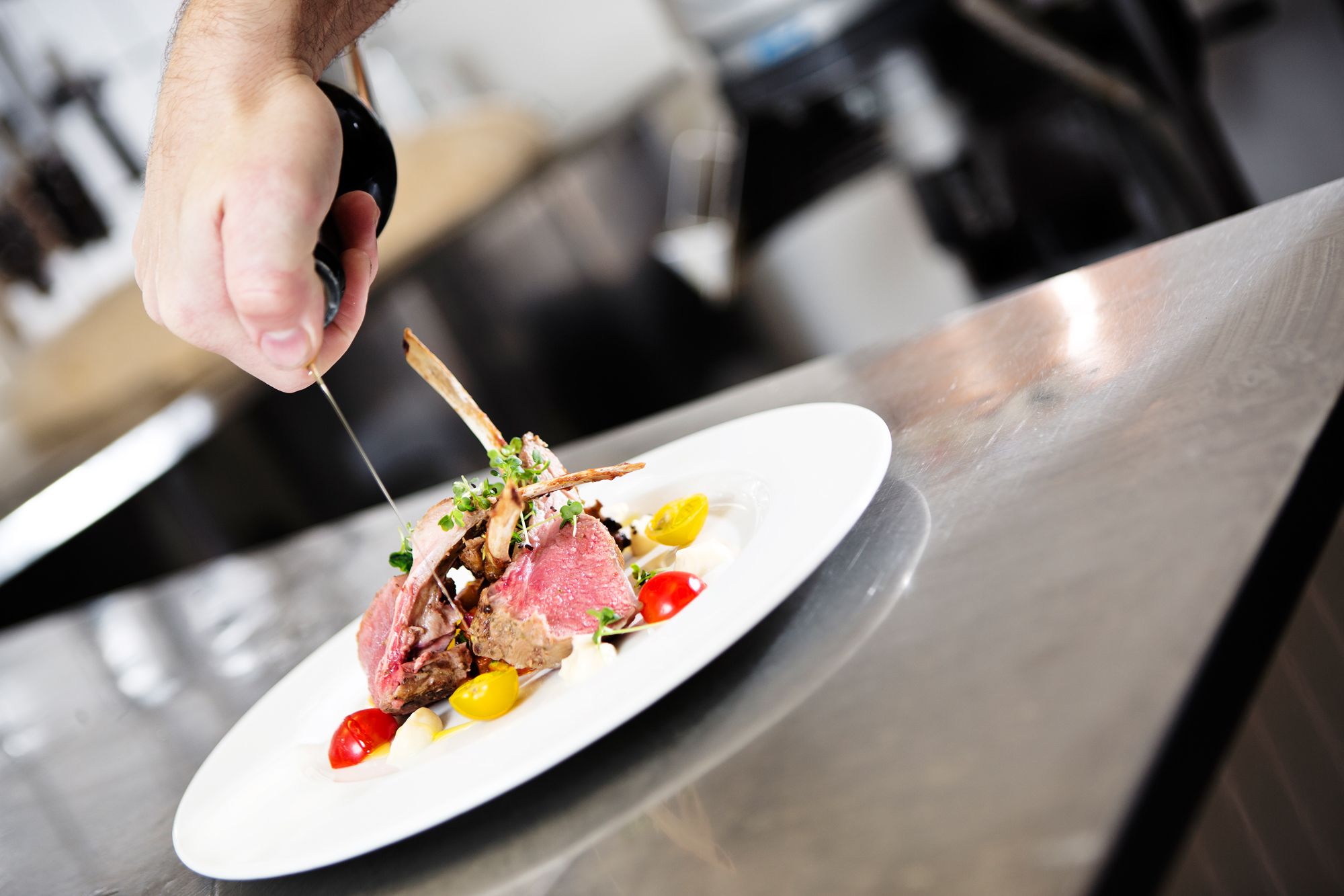 A chef slicing a dish with a fork.