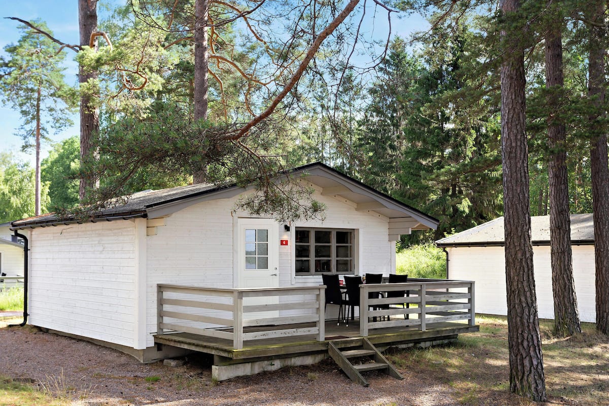 A small cabin with a porch, a door, and a window.
