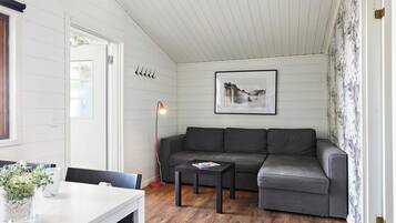 Una sala de estar moderna con un sofá seccional gris, una mesa blanca y un cuadro en la pared.