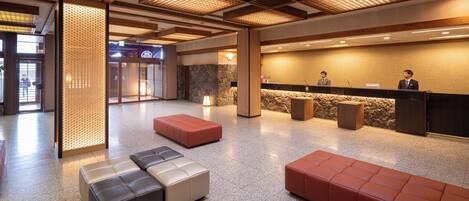 A lobby with seating areas, a reception desk, and a stone wall.