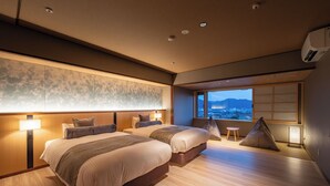 Una habitación de hotel moderna con dos camas, un ventanal con vistas a la ciudad y una puerta corredera japonesa tradicional.