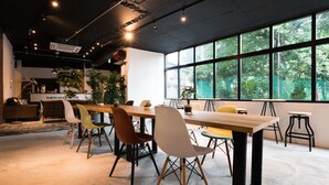 Una sala de reuniones moderna con una larga mesa, múltiples sillas y ventanas amplias que dan a vistas de zonas verdes.