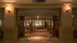 A hotel entrance labeled 'THE LIBRARY' with a reception area, seating, and decorative plants. - Sindbad Club (Hurghada)
