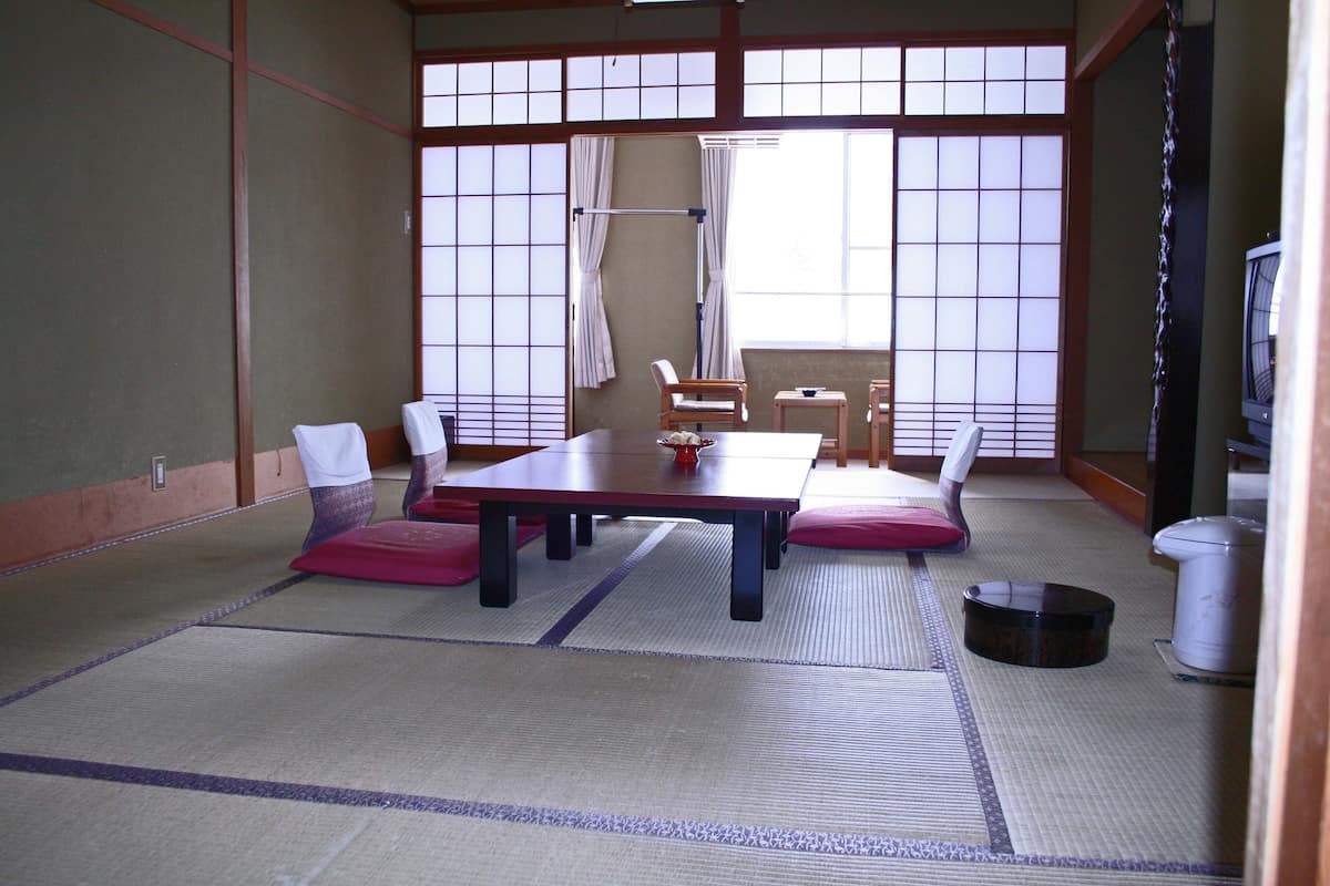 A traditional Japanese room with tatami flooring, a low table, and shoji screens.