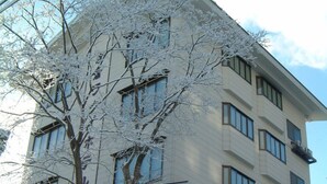 Un edificio de varios pisos con fachada simétrica, ventanas amplias y balcones.