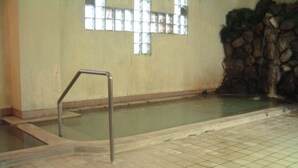 Una piscina con suelo de baldosas y barandilla de metal.