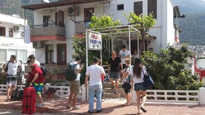 Un grupo de personas frente a un edificio con un letrero que dice "HILAL PANSIYON".