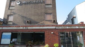 A building with a sign reading "TSUYAMA GRAND HOTEL" and another sign above it that says "TSUYAMA GRAND HOTEL". - Tsuyama Grand Hotel (Tsuyama)