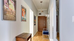A hallway with wooden flooring, a wooden bench, and a door at the end. - Oxford Family apartment in a quiet Sopot townhouse by Lion Apartments (Sopot)