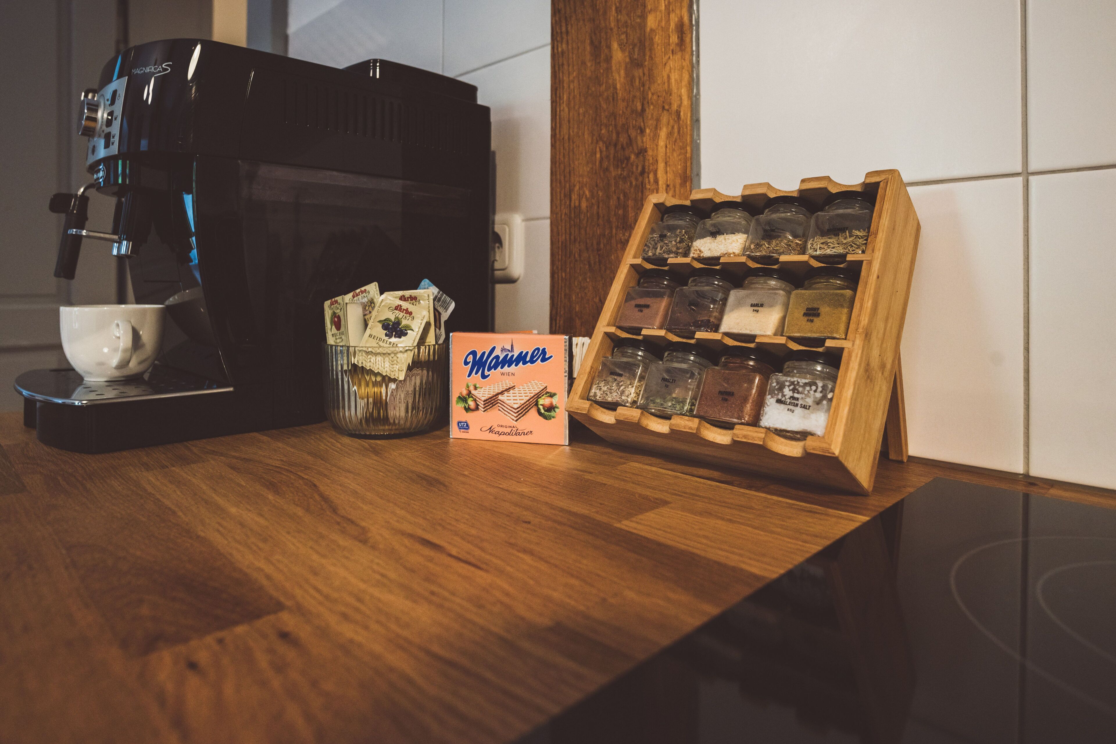 A coffee machine, a box of Manner Vienna chocolate, and a wooden display of chocolate bars on a wooden table.