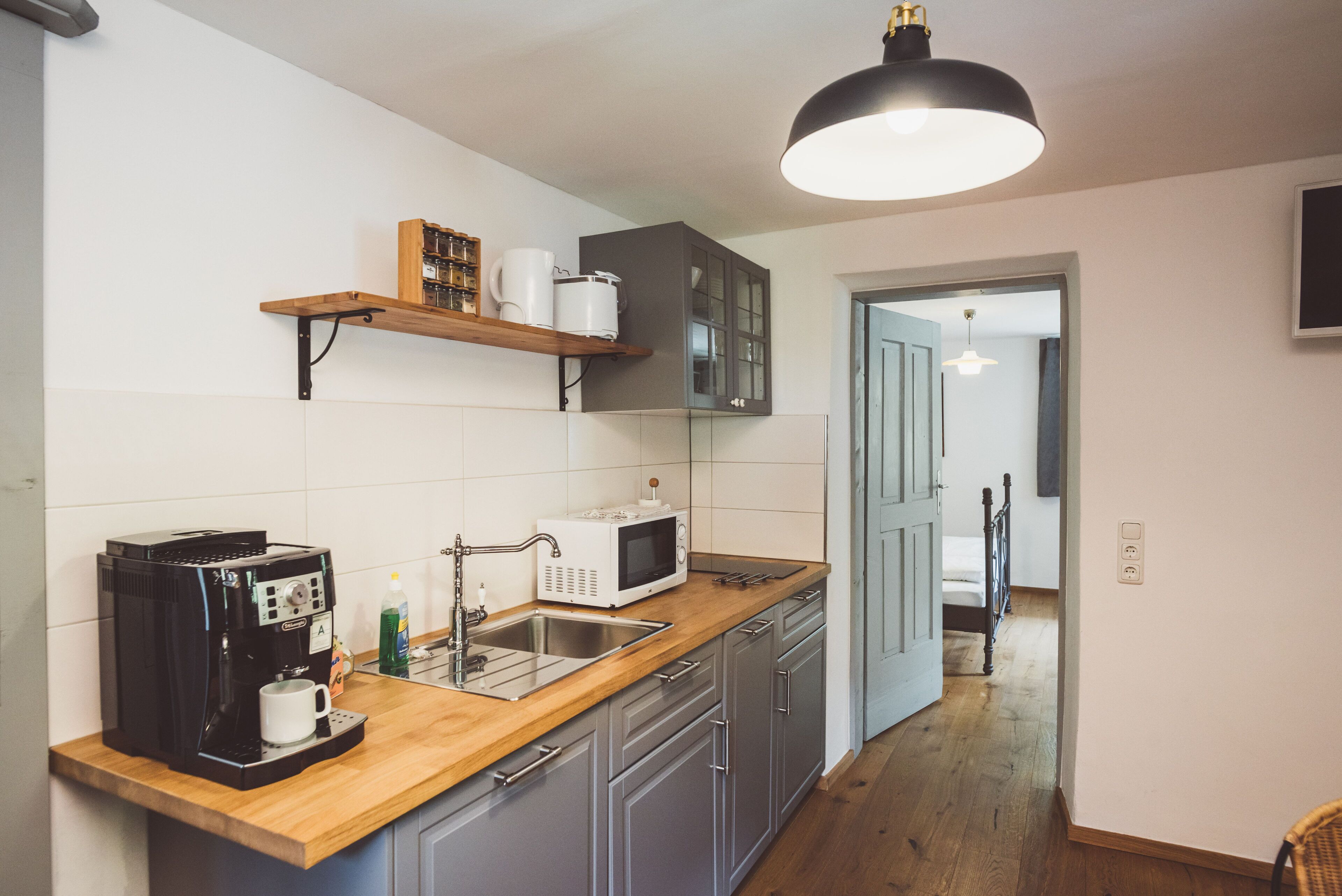 A kitchen with a coffee maker, microwave, and wooden countertop.