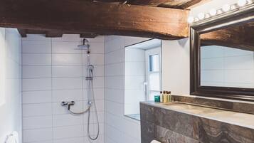 A bathroom with a shower, a sink, and a mirror.