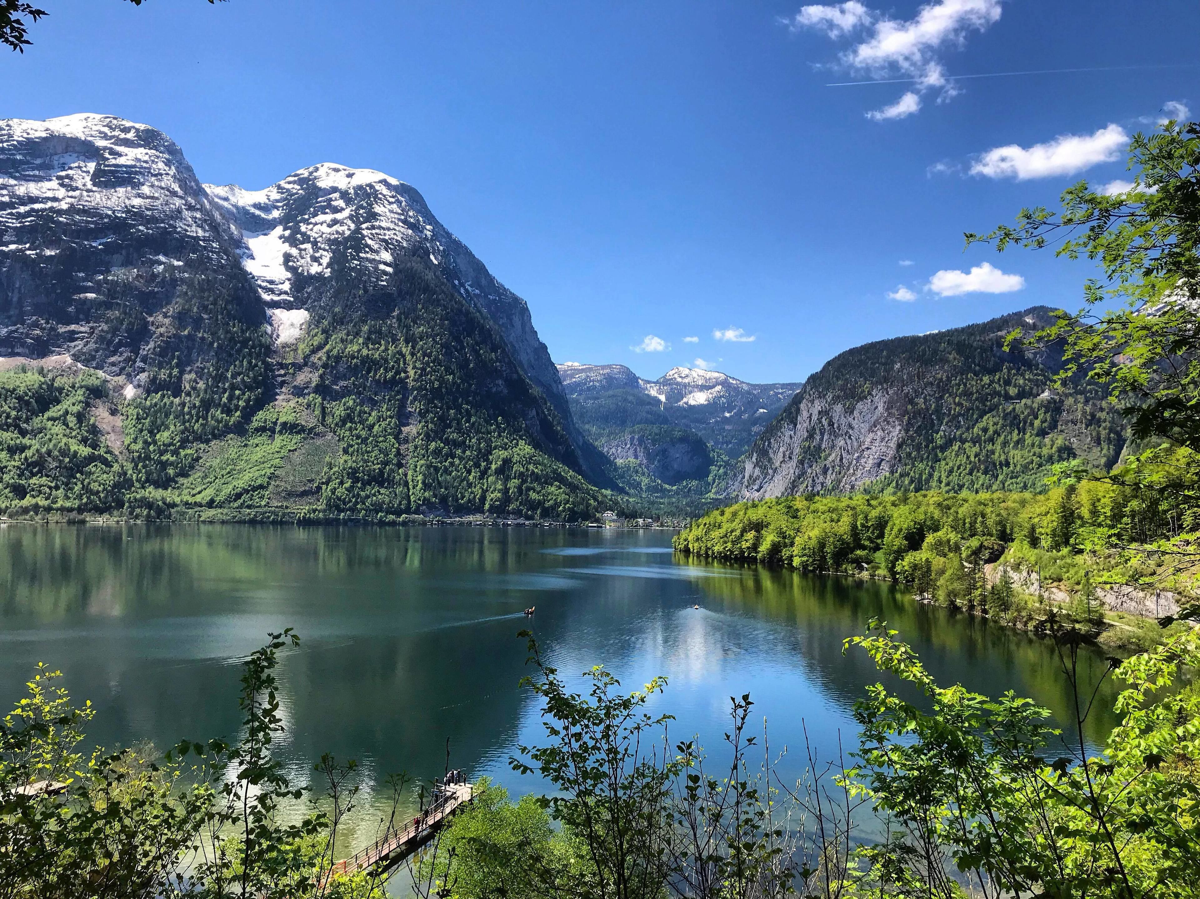 Un lac paisible, entouré de montagnes, sous un ciel dégagé.