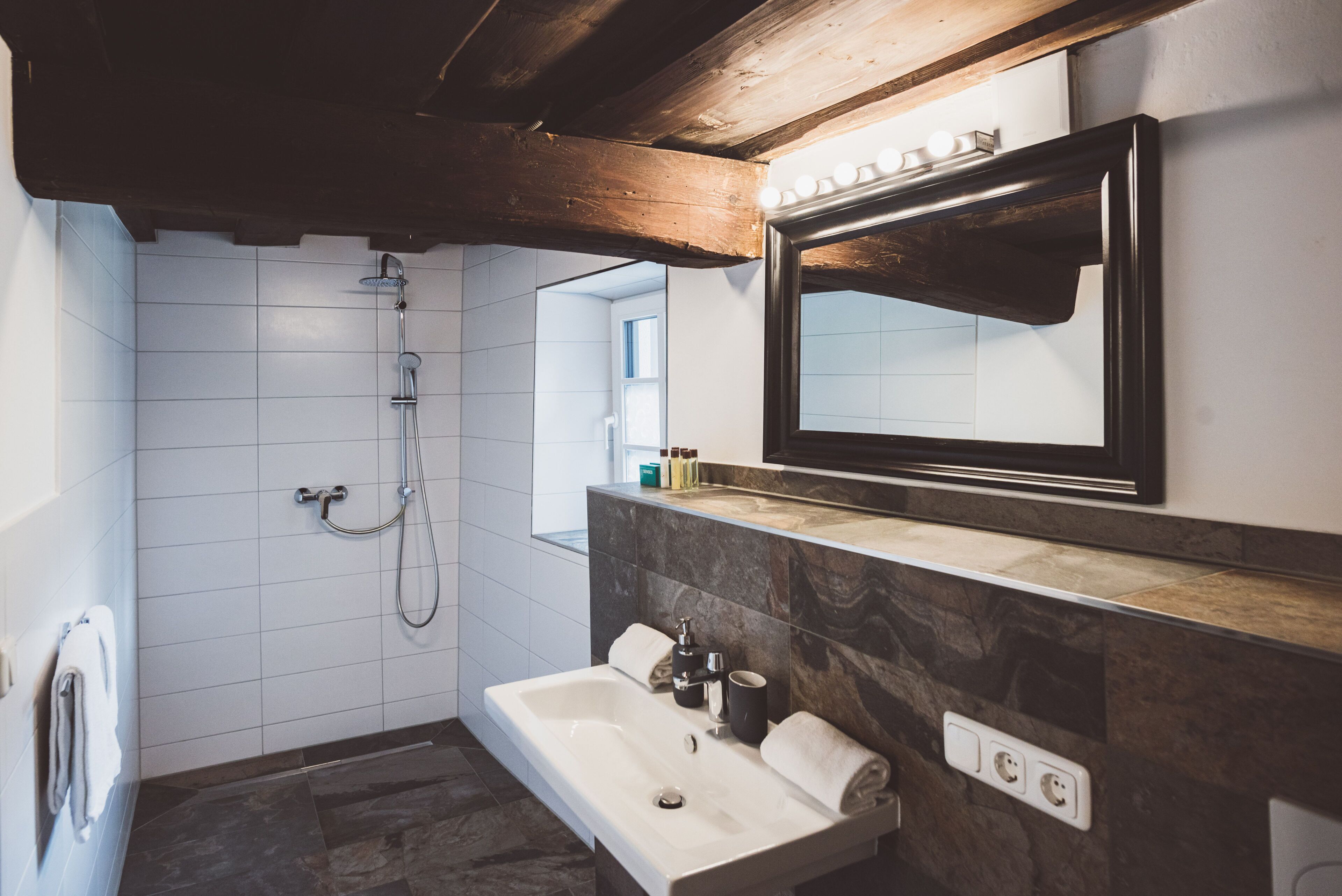A modern bathroom with a shower, a sink, and a vanity.
