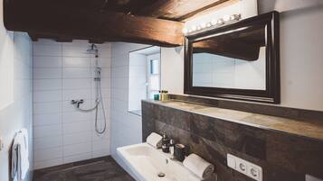 A modern bathroom with a shower, a sink, and a vanity.