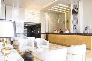 A modern hotel lobby with a reception desk, plush seating, and a large chandelier. - Platinum Seventy Serviced Apartments (Jeddah)