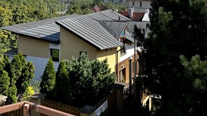 A residential building with solar panels on the roof, surrounded by trees and a clear sky. - Penzion Sofi (Prague)