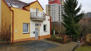 A yellow building with a balcony, a door, and a window. - Penzion Sofi (Prague)