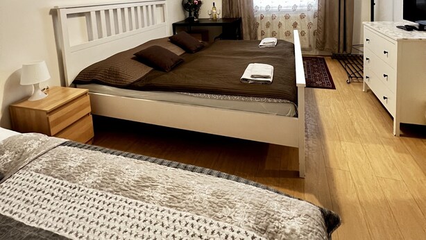 A neatly arranged bedroom with a bed, bedside table, lamp, and a dresser. - Penzion Sofi (Prague)