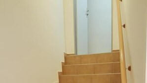 A staircase with wooden steps and a handrail, leading to a door at the top. - Penzion Sofi (Prague)