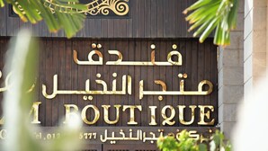 A boutique hotel sign with Arabic and English text, indicating the name and contact number.