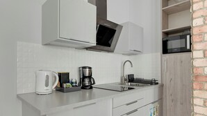 A modern kitchen with white cabinets, a Bosch kettle, a coffee maker, a microwave, and a sink. - Haffnera 19 - Sea & City Moments by Lion Apartments Sopot (Sopot)
