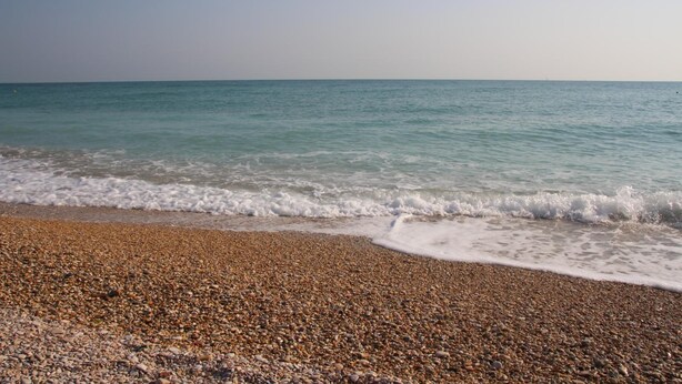 A pebbled beach with gentle waves lapping at the shore. - B&b Sogni d'Oro (Civitanova Marche)