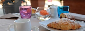 Una mesa con un pastel, una taza y un vaso de agua.