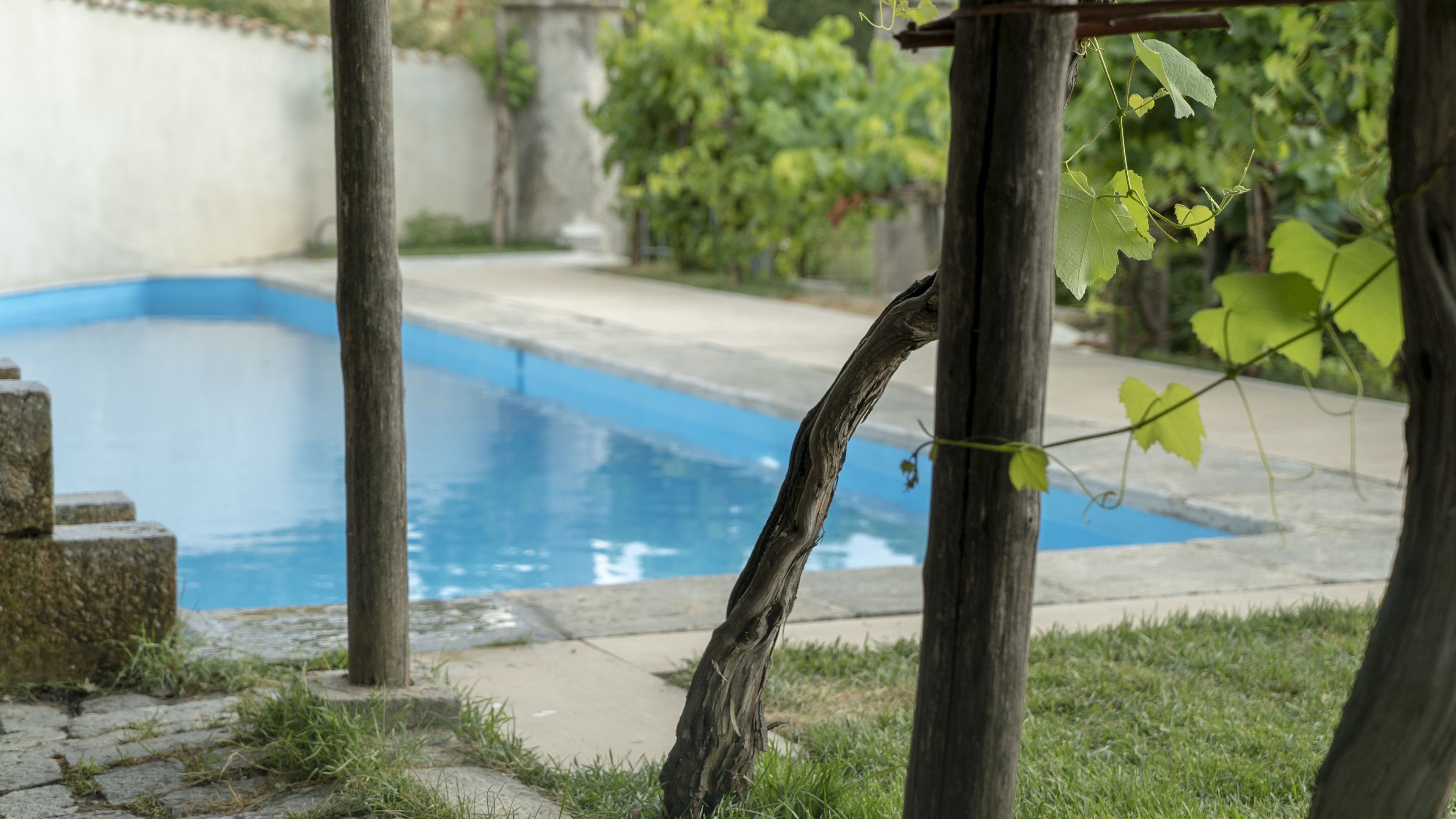 A swimming pool with a wooden structure in the foreground.