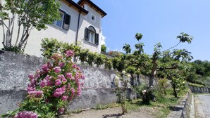 A building with a stone wall and flowering plants. - Il Casino di Donna Maria (Mormanno)