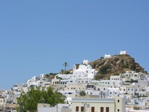 Une colline densément bâtie, recouverte de bâtiments blancs aux toits plats, qui semblent être des habitations ou de petits commerces.
