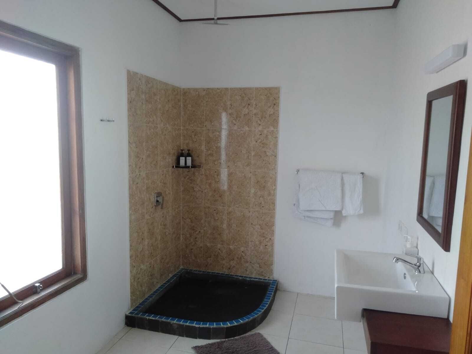Un bagno con doccia, vasca e lavandino.