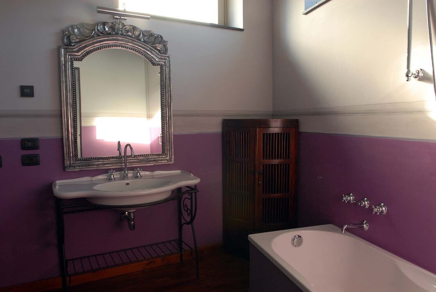 A bathroom with a sink, mirror, and bathtub.
