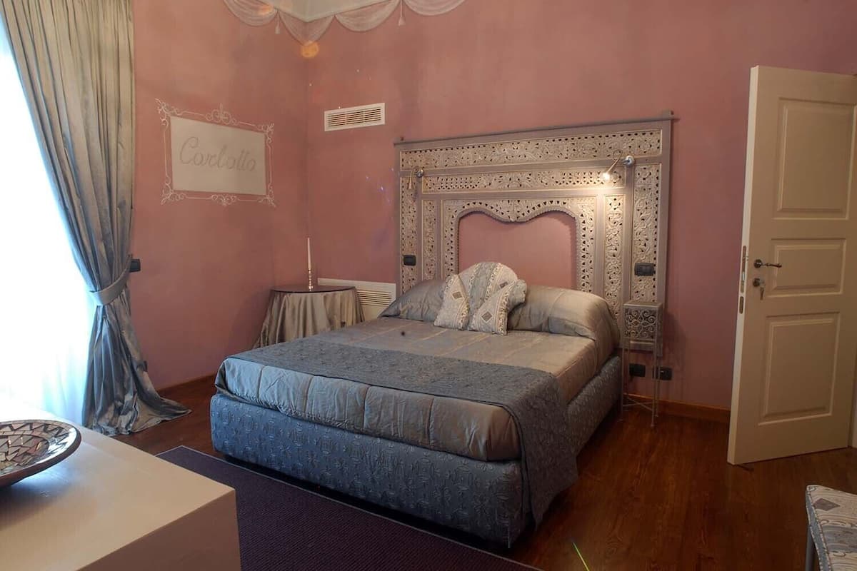 Un dormitorio con cama, mesita de noche, cómoda y puerta.