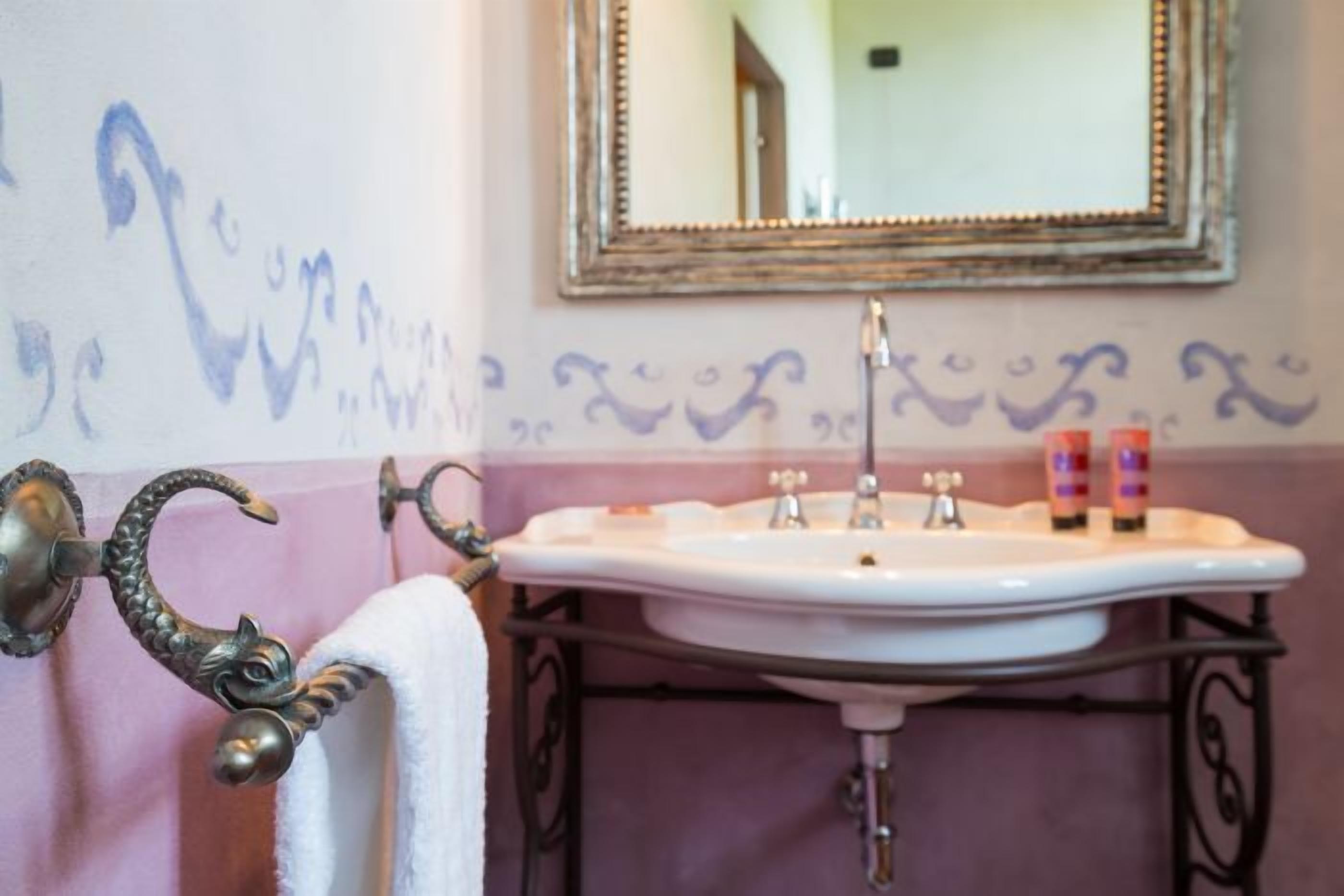 Ein Badezimmer mit einem weißen Waschbecken, einer verzierten Türgriff und dekorativen Wandmustern.