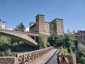 A stone bridge leading to a historic building with multiple windows and a tower. - Castello di Pontebosio Luxury Resort (Licciana Nardi)