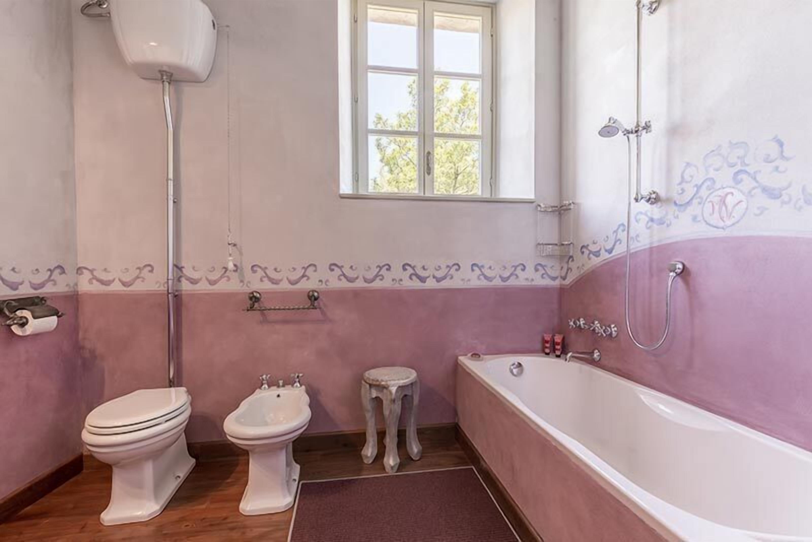 A bathroom with a toilet, bidet, and bathtub.
