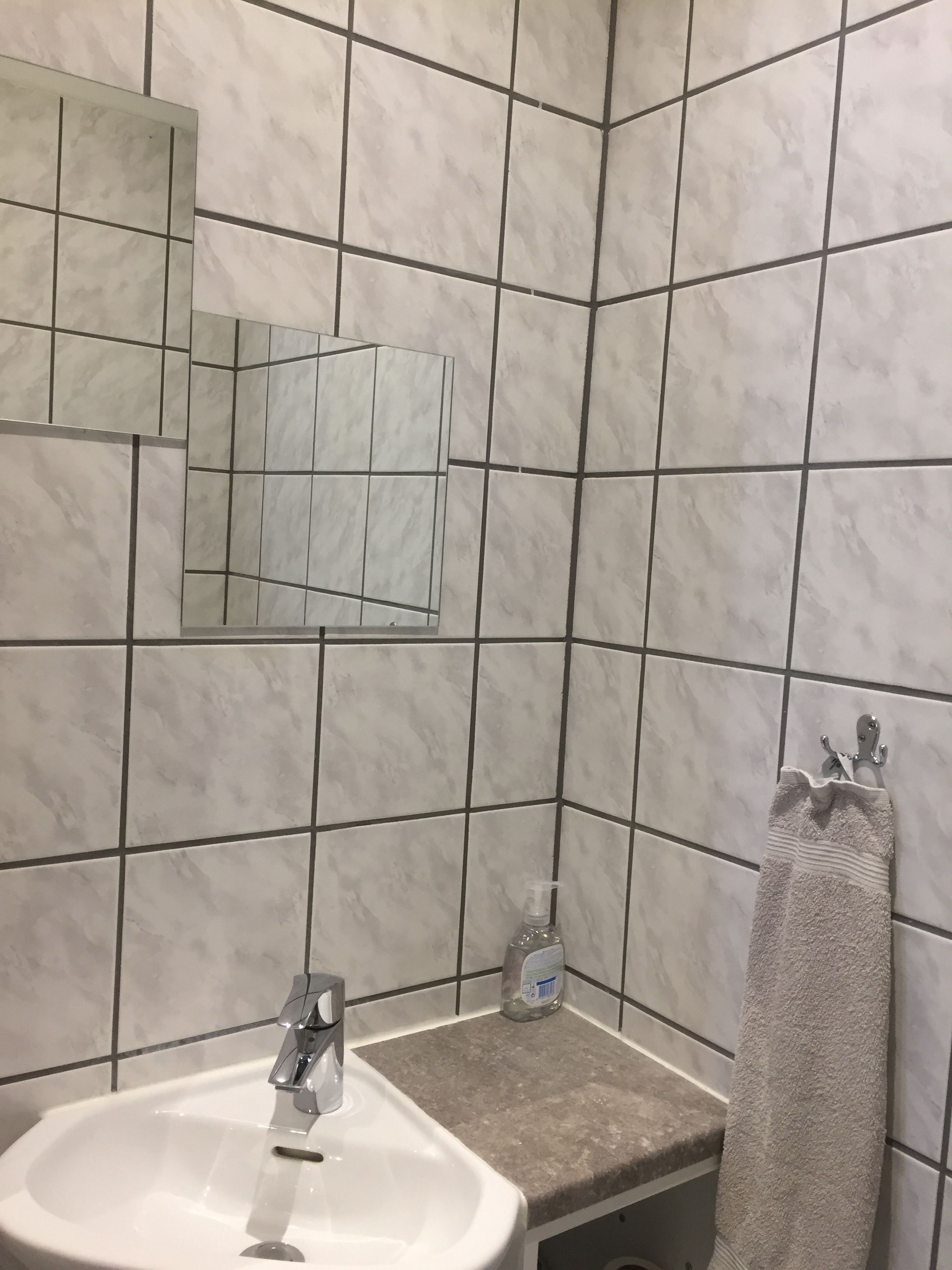 A bathroom with a white sink, a mirror, and a towel rack.