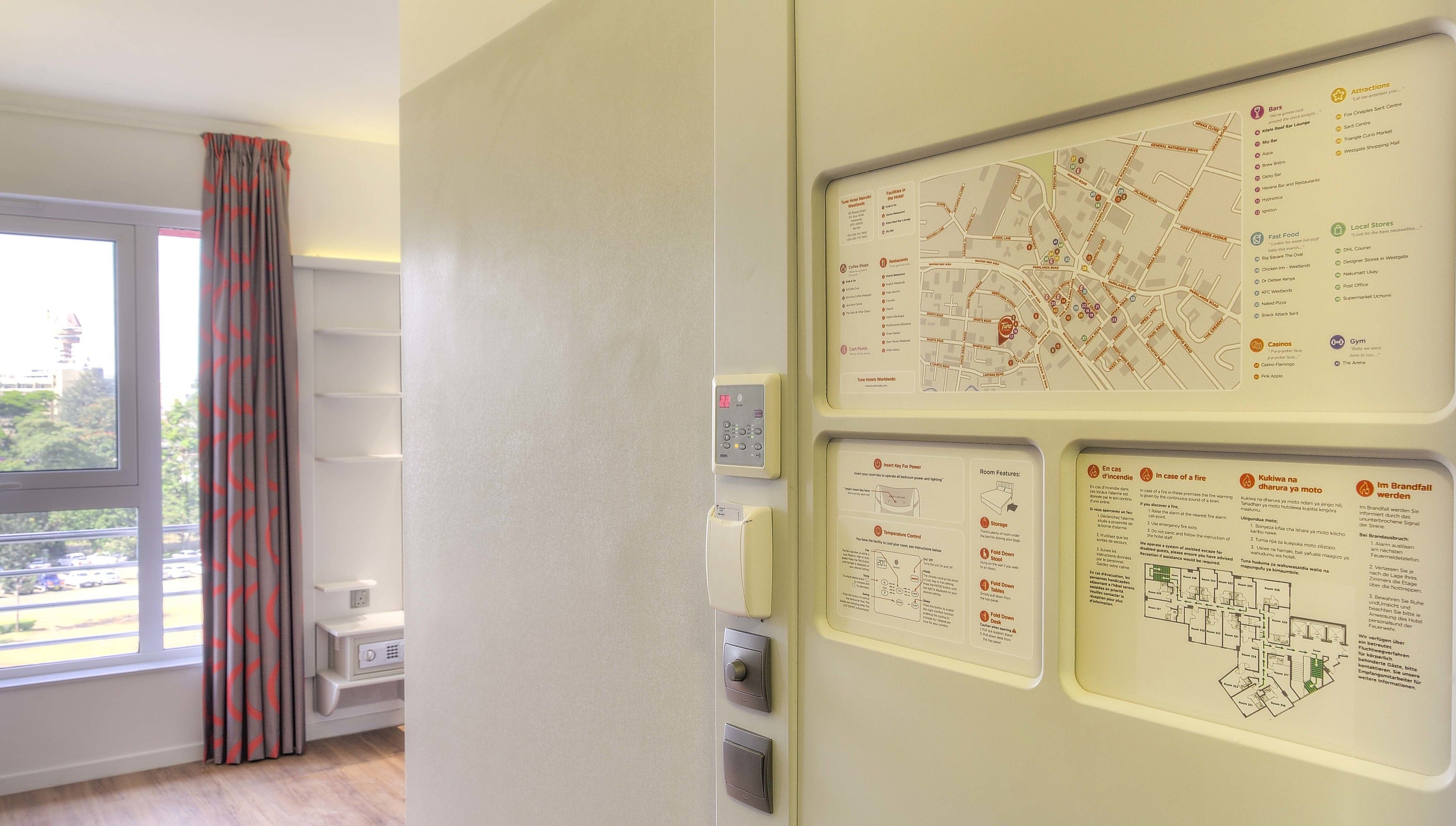 Une chambre d’hôtel équipée d’un grand panneau d’information détaillant les attractions locales, les options de restauration et les équipements de la chambre.